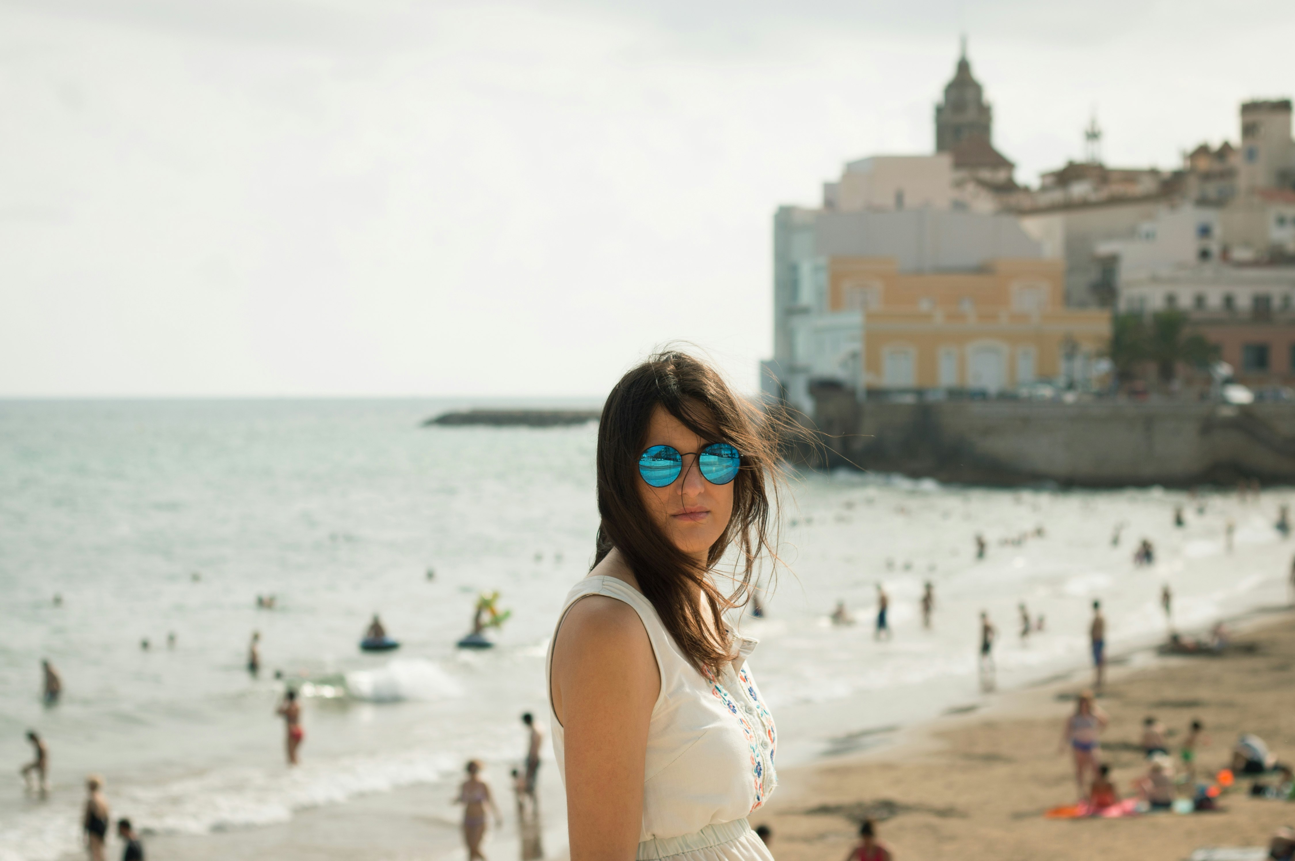 woman in white sleeveless top near seashore